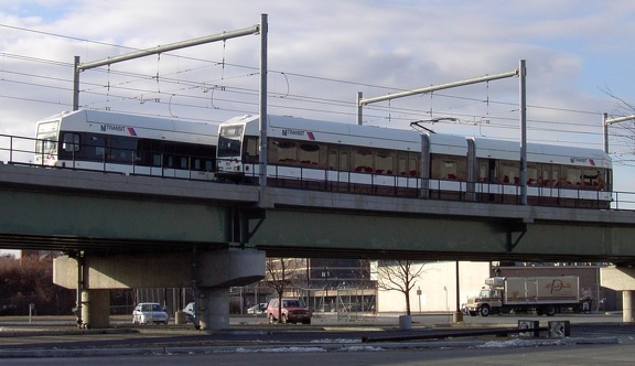 A southbound LRV passes a parked LRV (on the center track) above the parking lot of the International Foodmart in Newport. Photo