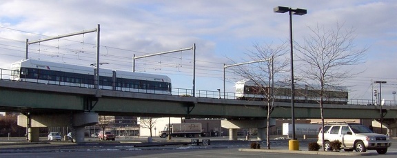 A southbound LRV passes a parked LRV (on the center track) above the parking lot of the International Foodmart in Newport. Photo
