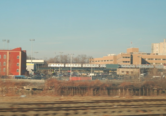 A train of R-62A cars travels north along the route of the (1) just south of the Broadway Bridge. The train is out-of-service as