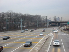 Northbound lanes @ New York State Thruway's New Rochelle Toll Barrier. The Northeast Corridor rail line is in the background, wi
