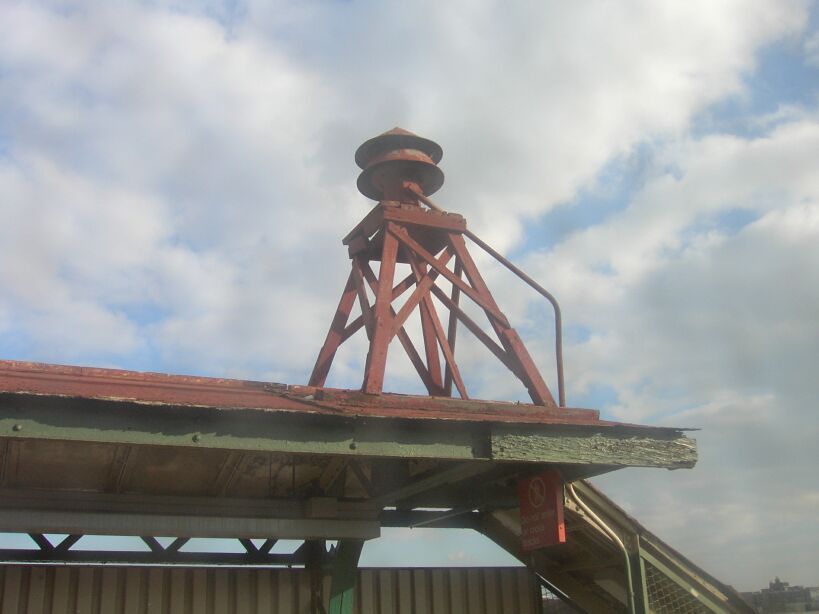 Air raid siren on the roof of the nb platform @ Sutter Av (L). Photo taken by Brian Weinberg, 12/29/2002. (60k)